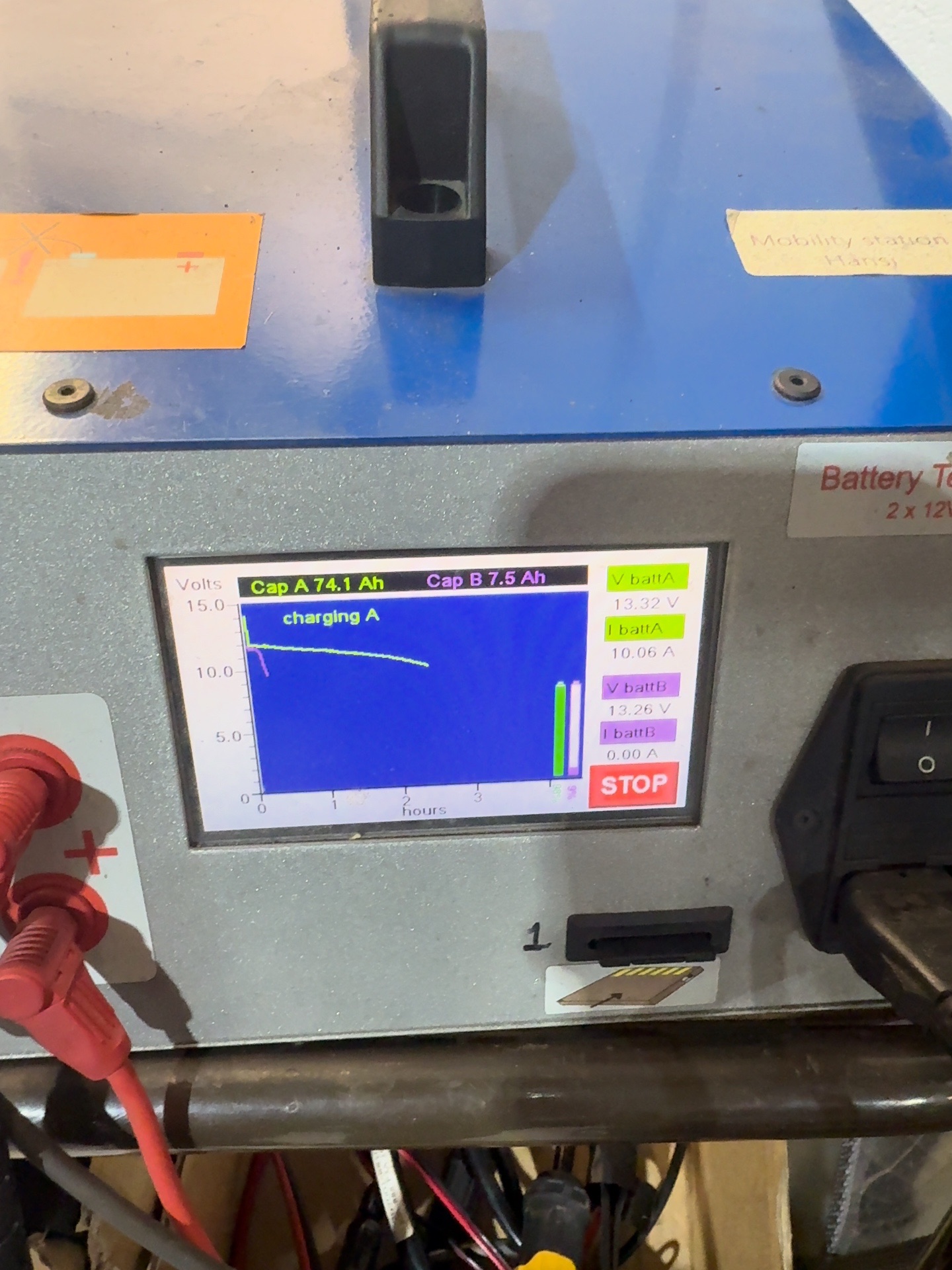 Technician testing battery voltage on a mobility scooter