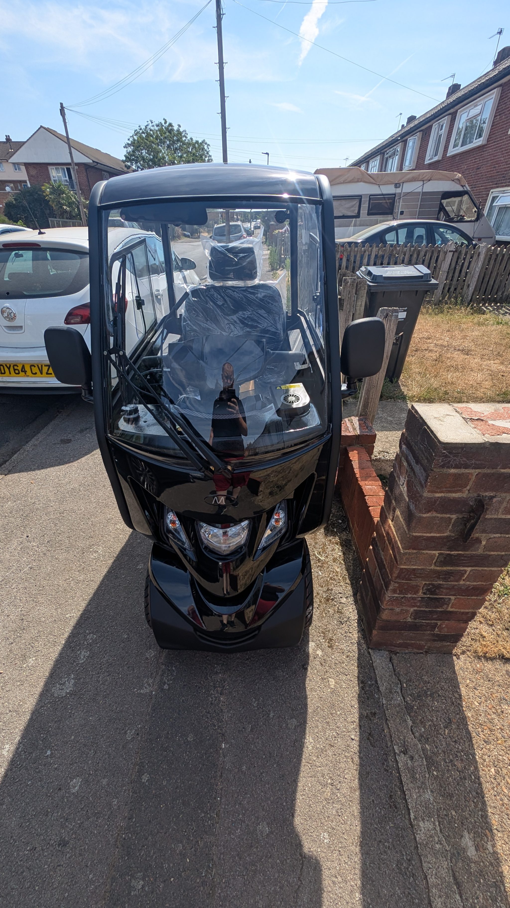 Side profile showing the enclosed cabin and sturdy tyres on the Xplorer scooter