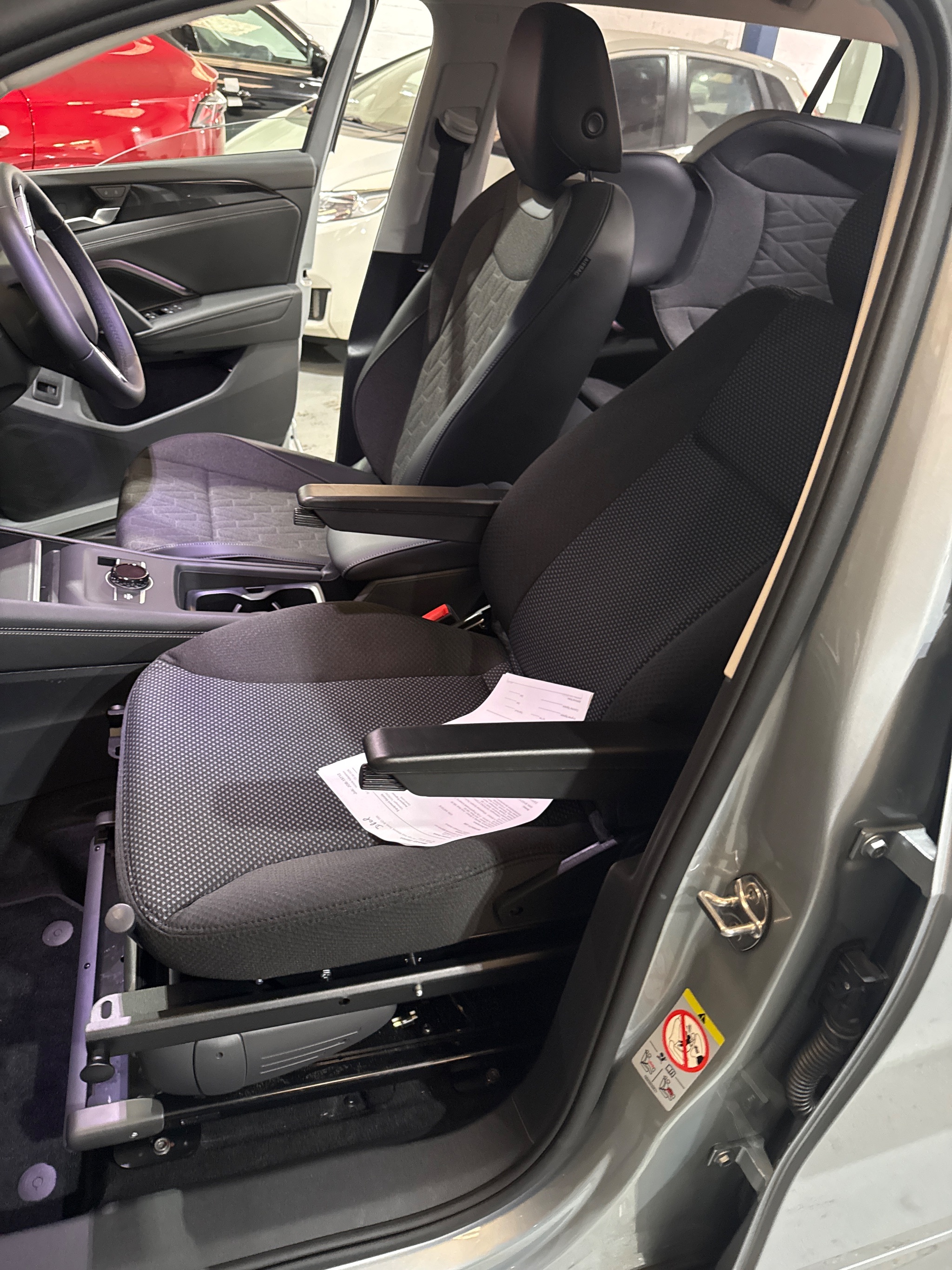 Technician demonstrating the electronic hand control for the swivel seat system