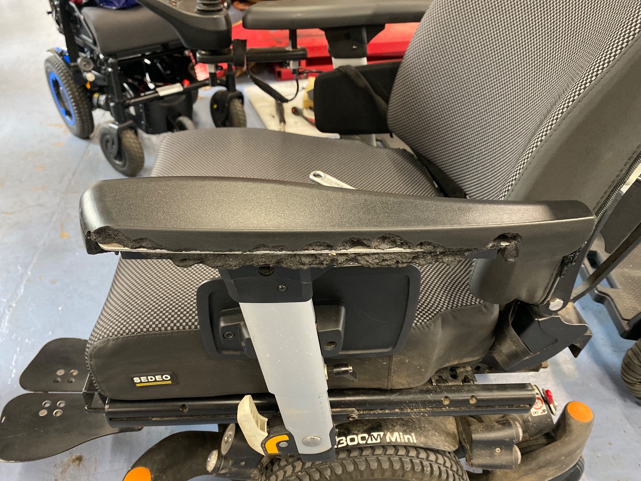 Technician inspecting a powerchair during a routine service