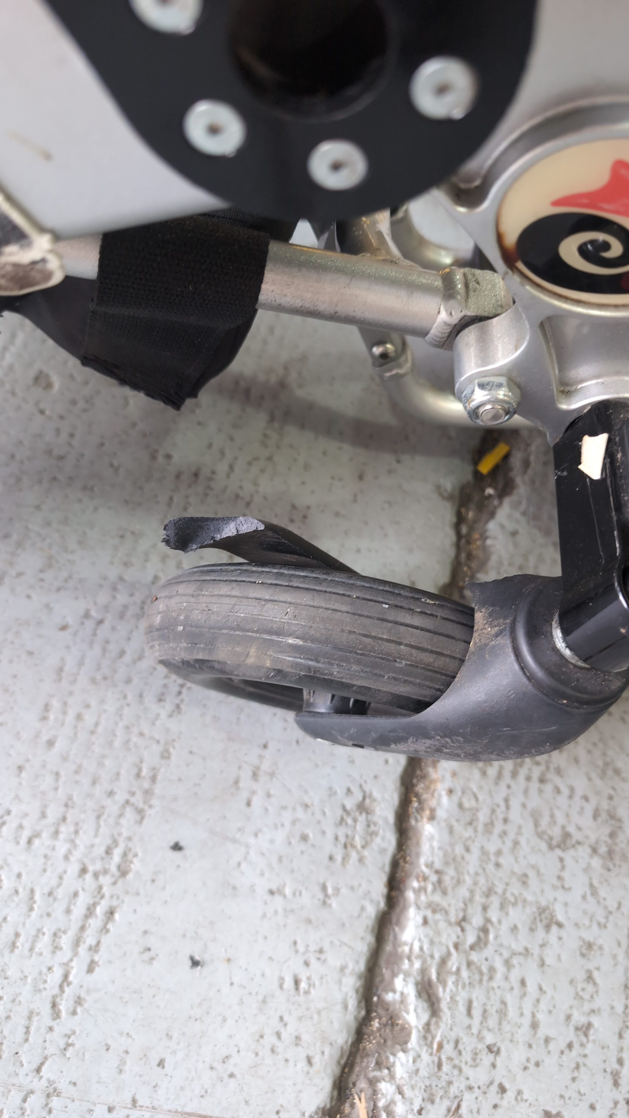 Close up of damaged front castor fork on power wheelchair