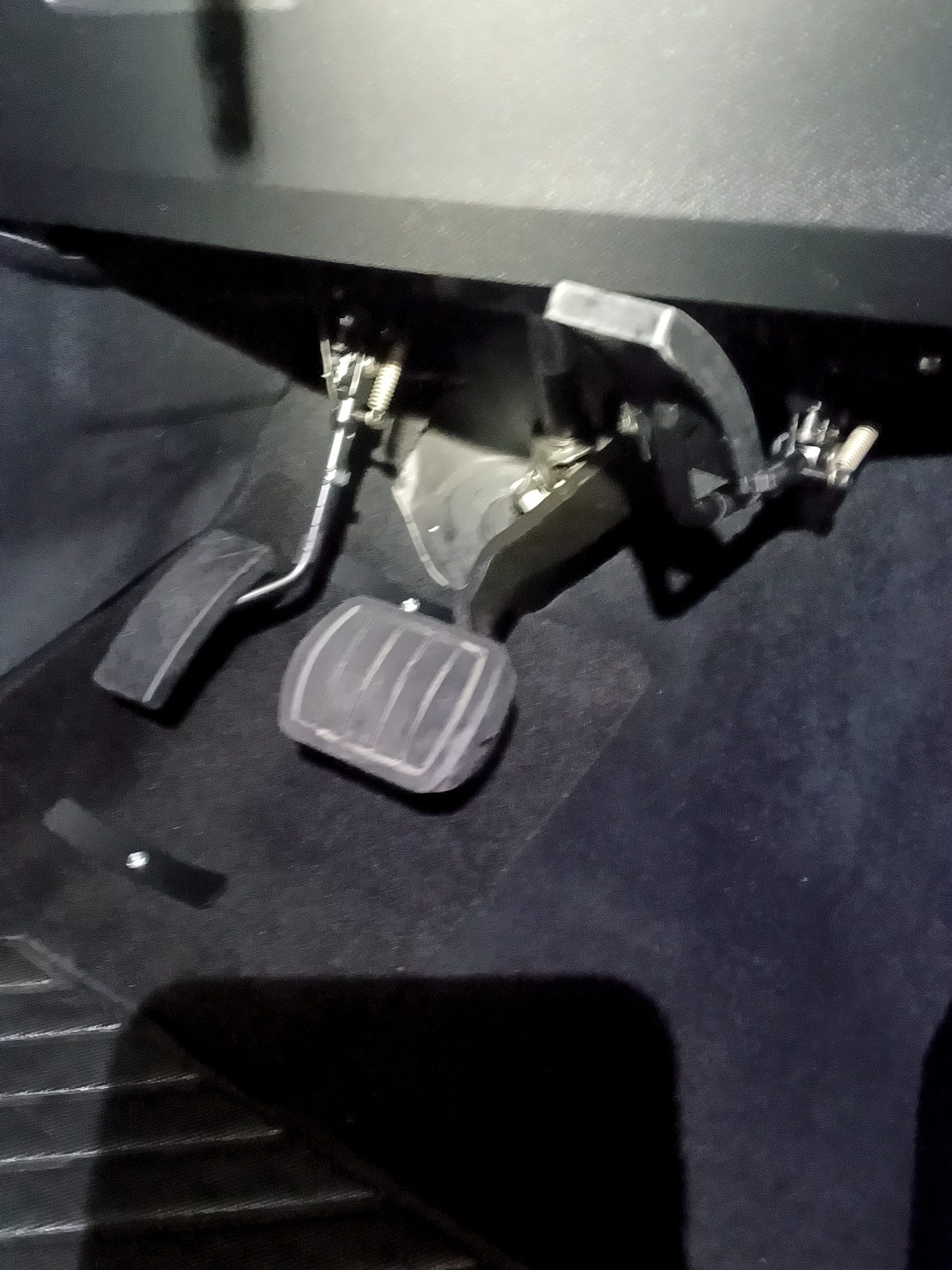 Close-up of the folded left foot accelerator mechanism in the vehicle